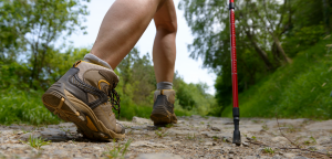 nogi osoby przemierzającej szlak w butach trekkingowych