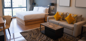 elegancki pokój hotelowy z łóżkiem i niewielką strefą wypoczynkową
