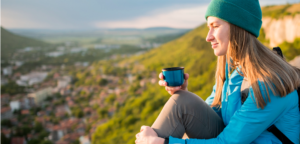 kobieta pijąca herbatę w trakcie wycieczki górskiej